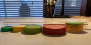 row of assorted jar lids in order by height