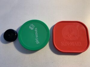 3 lids in a row: small round black, larger round green, larger square red (to start a pattern)