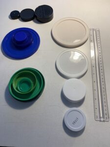 4 ways to show lids of one color sorted by size: sm, med, lg black lids in a row; green lids nested; blue lids stacked; white lids lg to small beside a ruler
